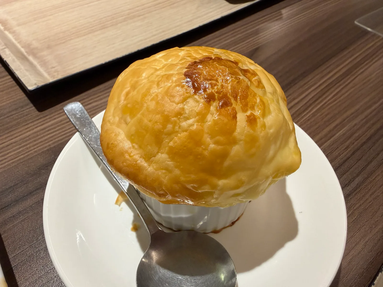 ふくらんだパイ包みのスープ。スプーンが添えられている