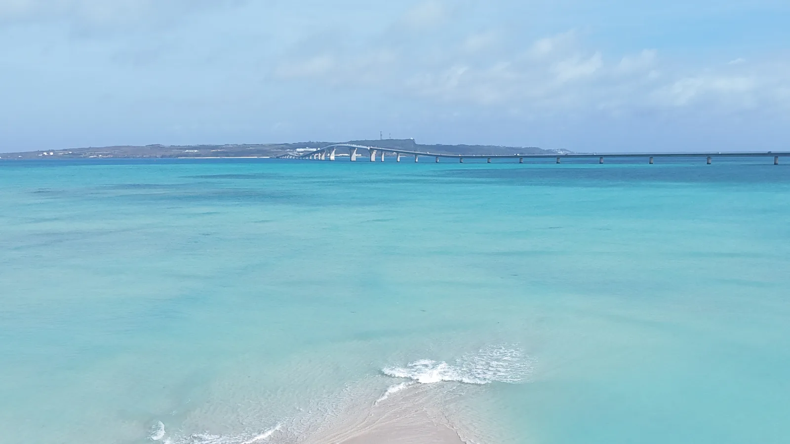 ユニの浜の海と、遠くに伸びる橋